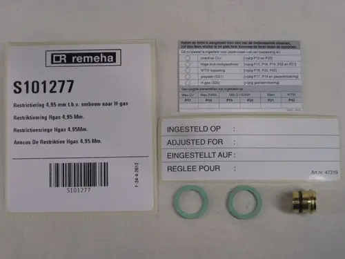 Kleine goldene Metallring mit zwei grünen Dichtungen und Informationsetikett zur Restriktion von Gas, Marke Remeha, sowie Anweisungen zur Umstellung auf H-Gas.